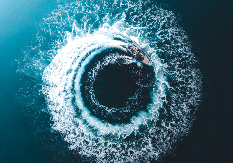 A stock image of a boat on water, riding in a circle.