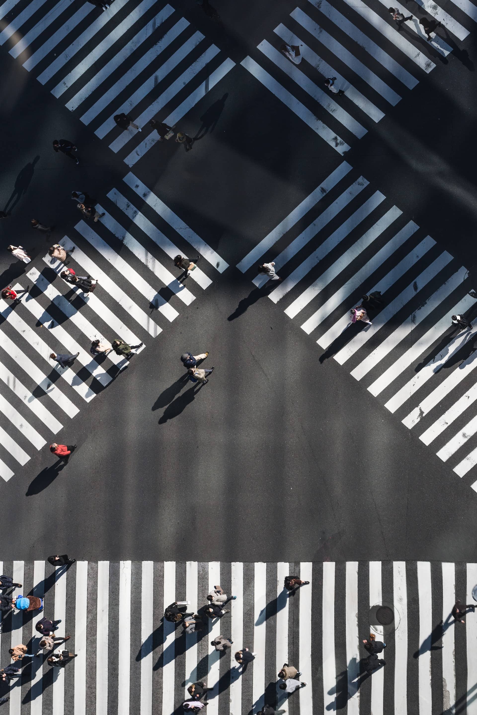 Aerial image of people walking across a busy intersection.