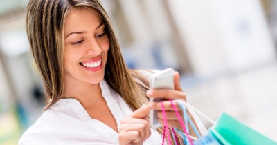 Happy woman using cell phone at a shopping center-1-1