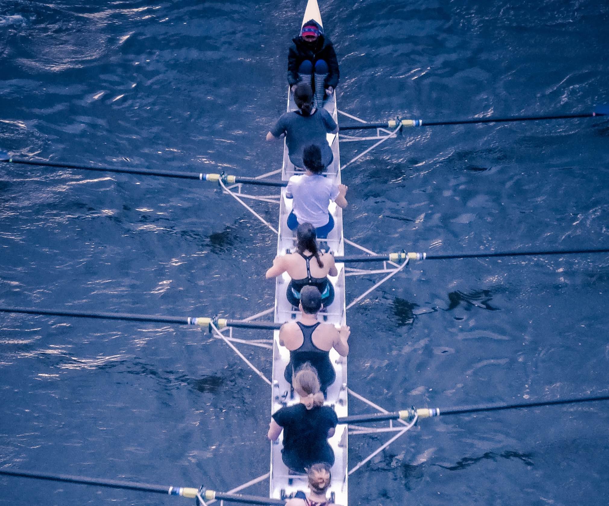 a group of women rowing a row boat