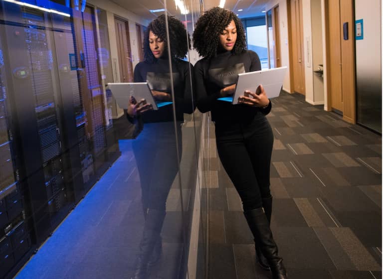 A woman reviewing an IT plan on a laptop in an office.