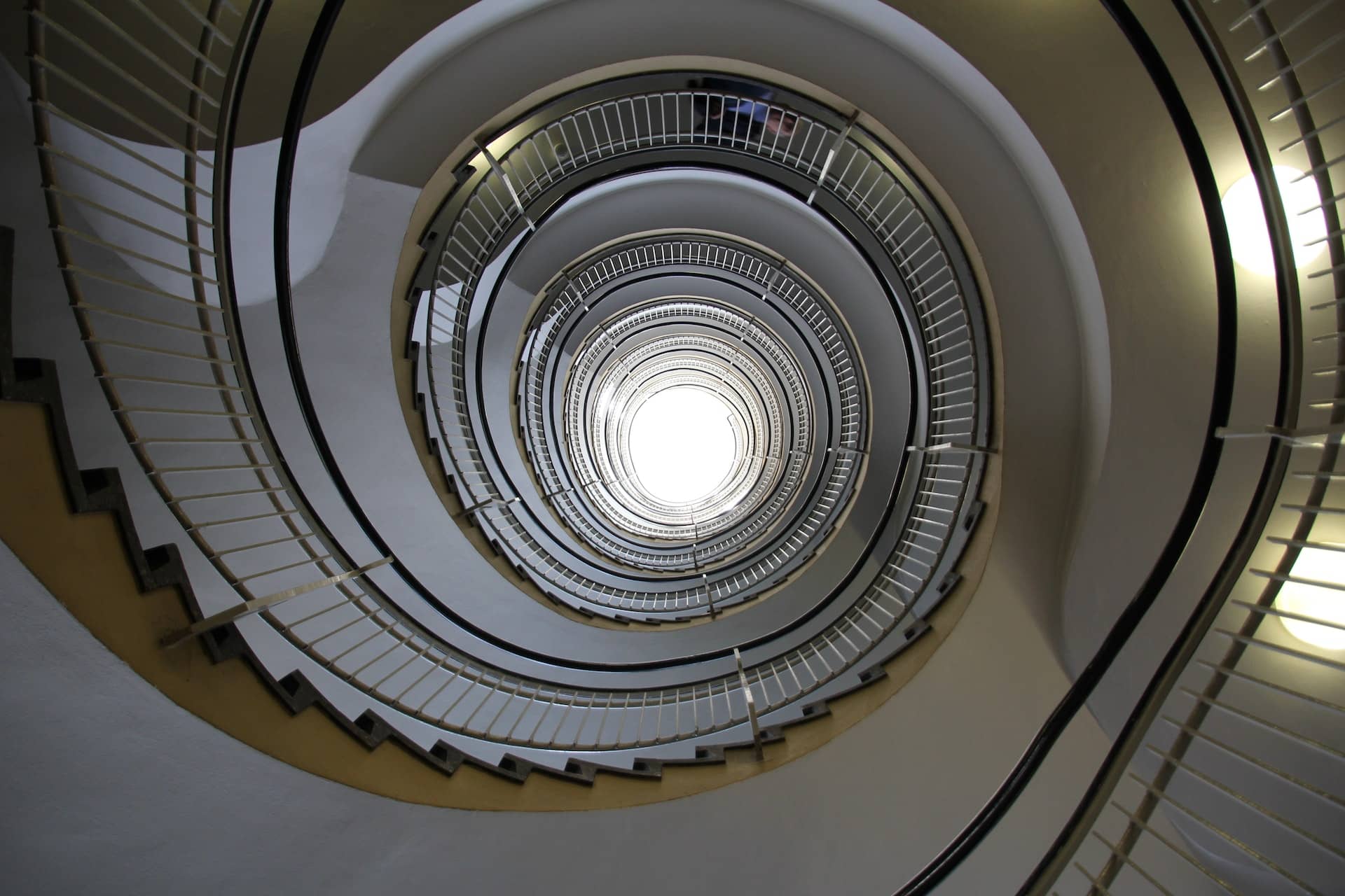 View looking up from the center of a spiral staircase.