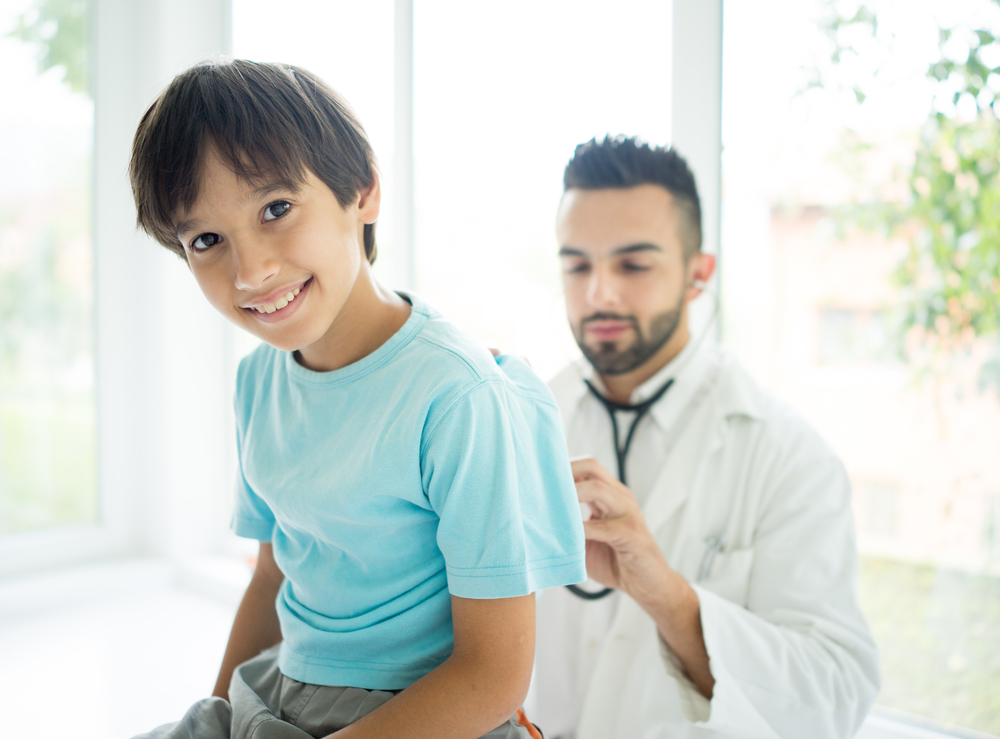 Doctor examining a school boy at hospital