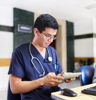 A healthcare professional interacts with a tablet.