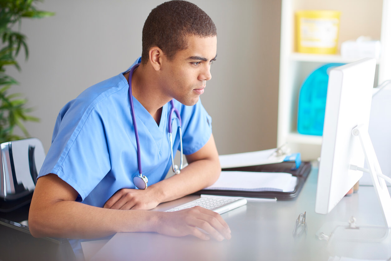 A healthcare worker uses a desktop computer.