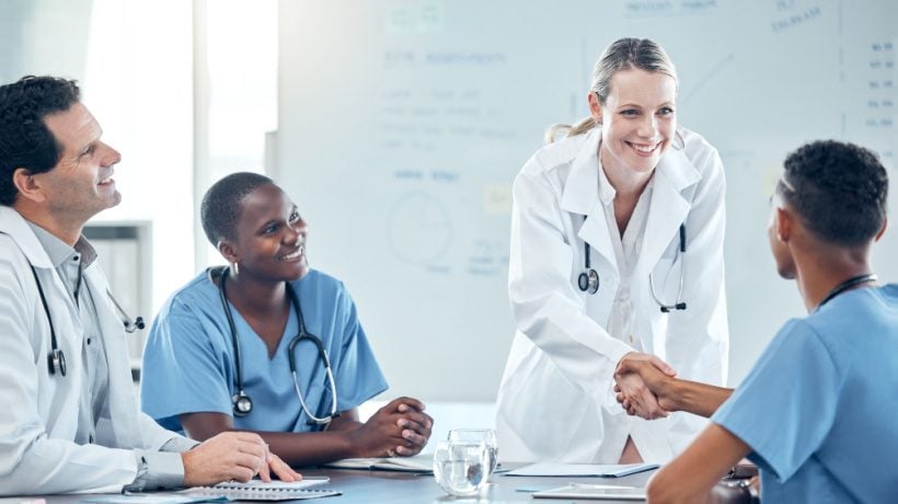 a group of doctors smiling and shaking hands