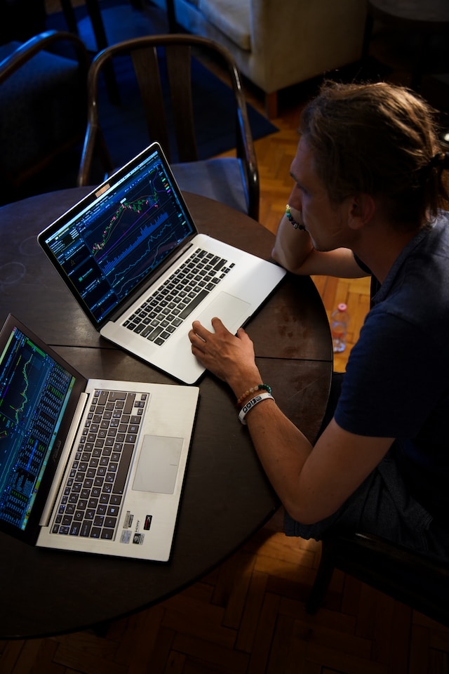 A stock image of a man with two laptop computer screens in front of him.