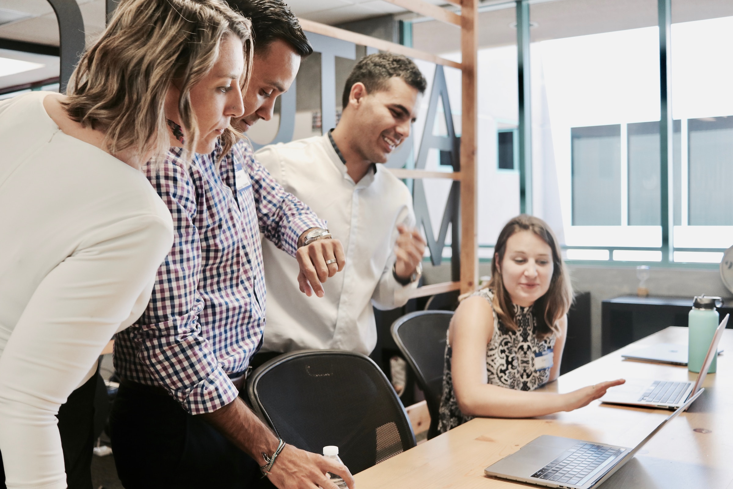 A group of people work together at laptops.