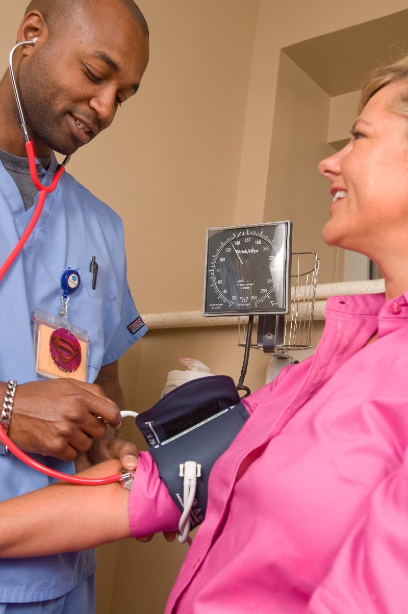 A medical professional takes a patient's blood pressure.