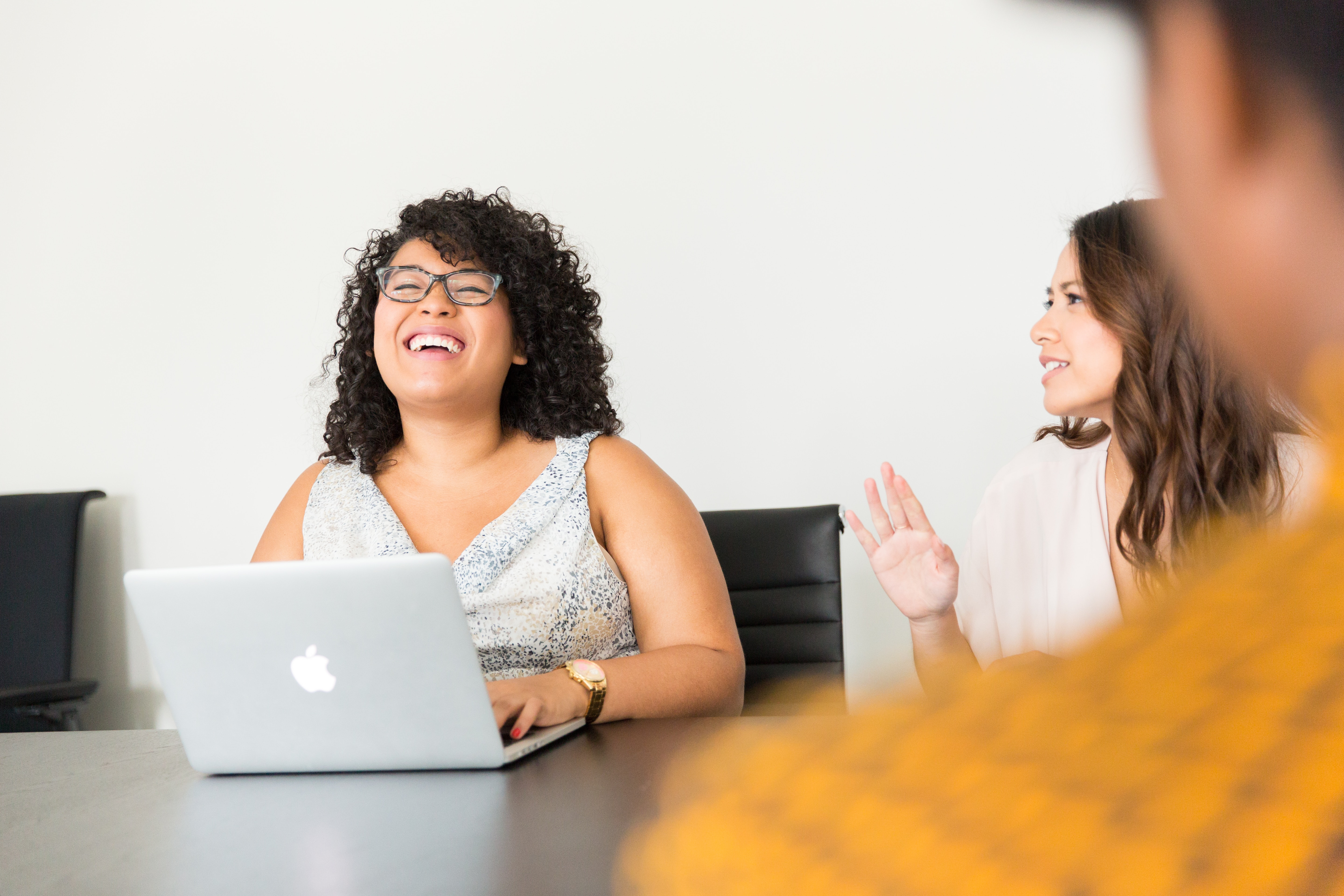 Strategy professionals smile as they discuss during a meeting.