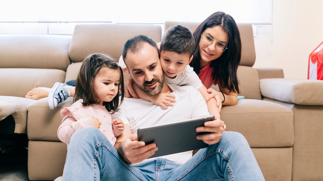 a family looking onto a tablet