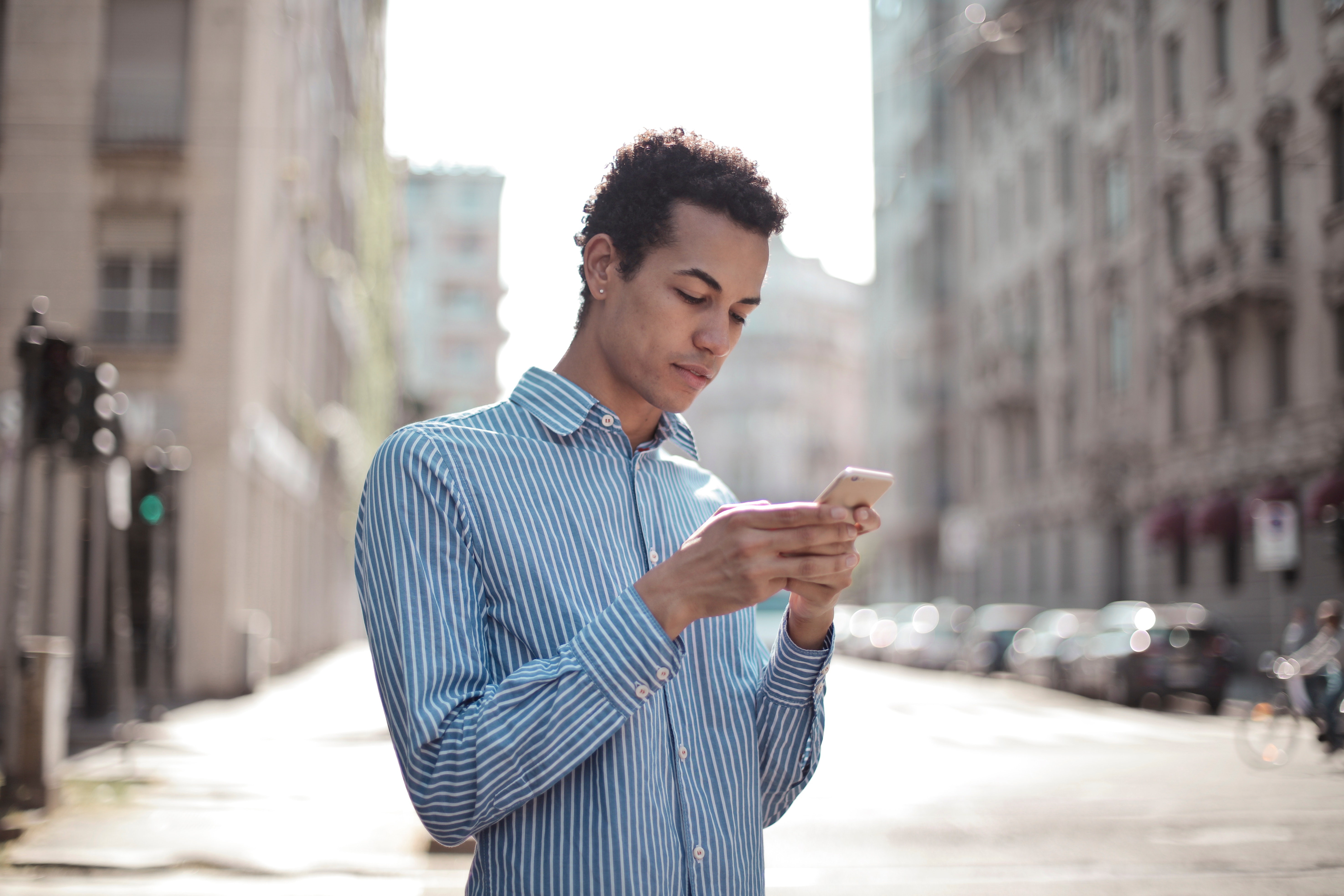 A person uses a smartphone in a city.