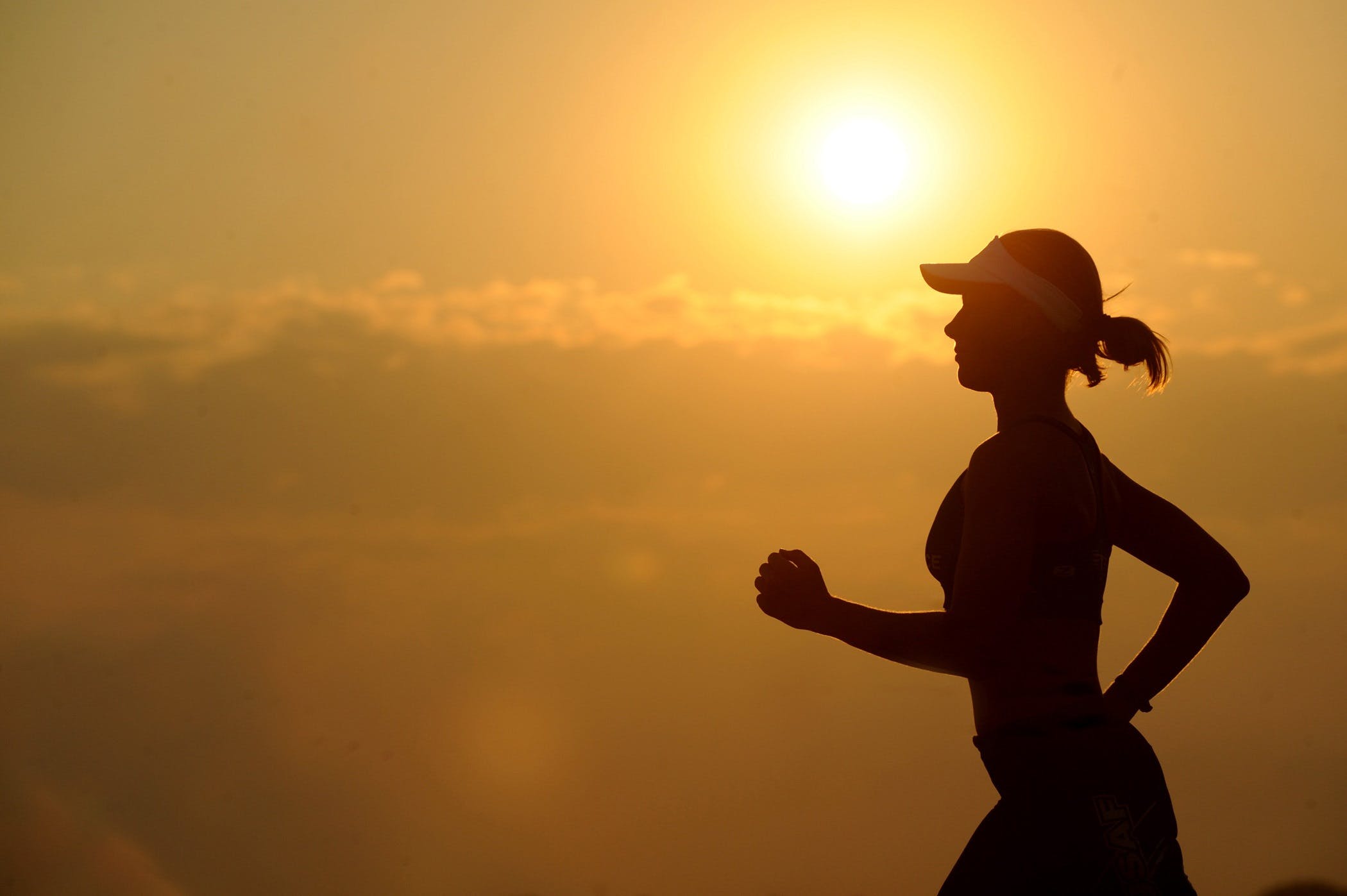 A person running with the sun behind them.